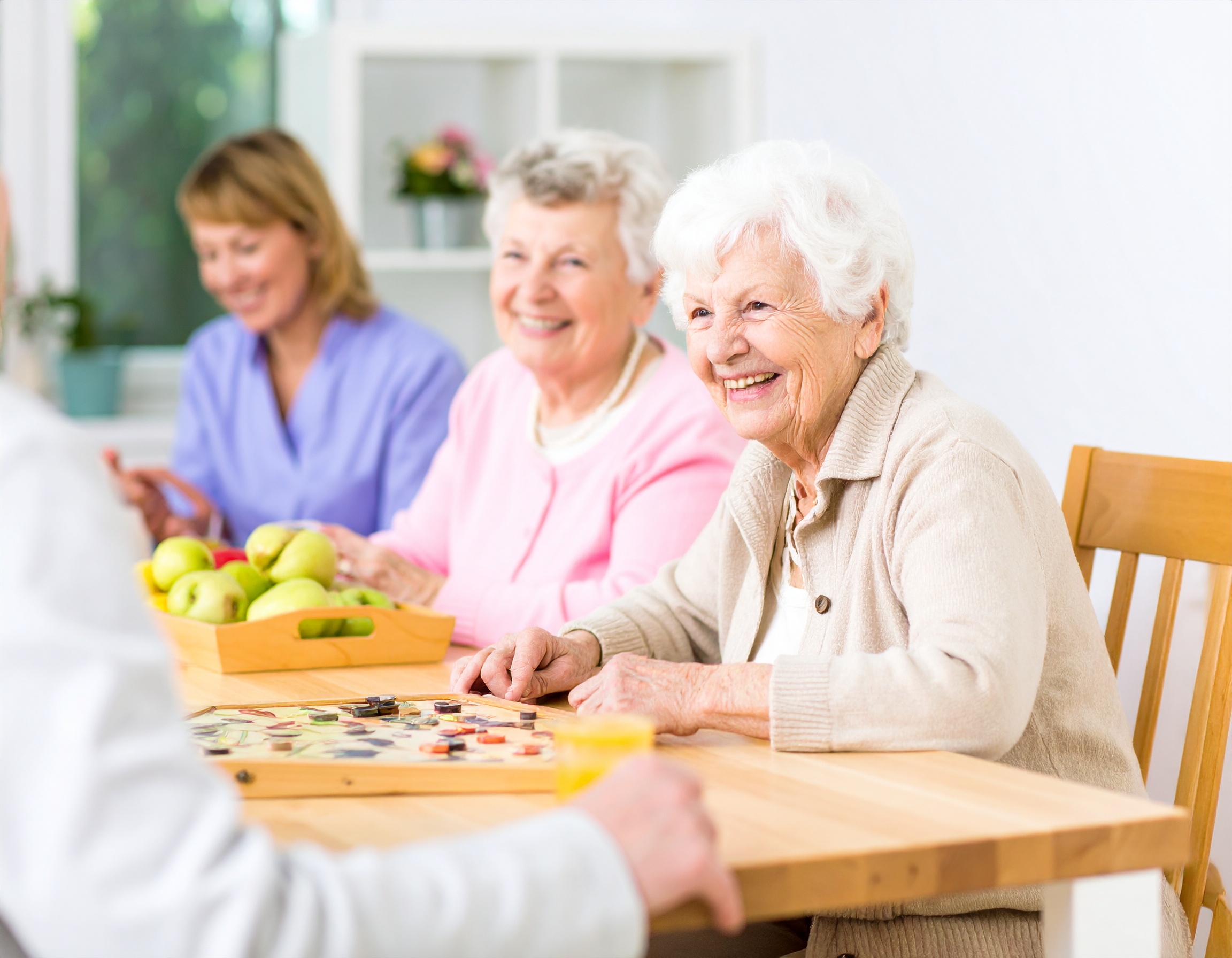 Ältere Menschen genießen gemeinsame Aktivitäten in einer Tagespflegeeinrichtung – betreut von freundlichem Pflegepersonal in wohnlicher Atmosphäre.